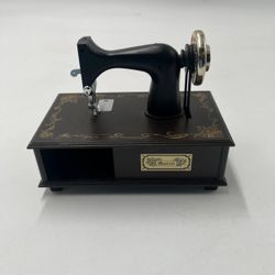 The Vintage Berkeley Designs Small Sewing Machine Musical Box is a charming and nostalgic decorative collectible that doubles as a music box. Manufact
