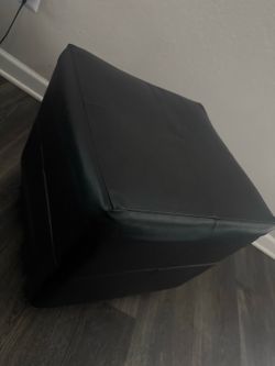 A black faux-leather storage ottoman or cube seat.