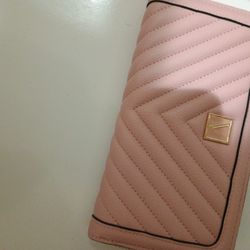 This is a Victoria's Secret "The Victoria" large zip-around wallet in an orchid blush pink color with V-quilt design and V-monogram hardware. 