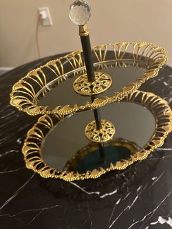 Gold colored, two-tier serving tray with mirrored surfaces,