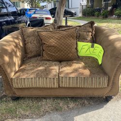 Brown loveseat with patterned pillows 