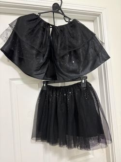 Little black capelet with black skirt and shorts underneath shorts have elastic on the waist size 12