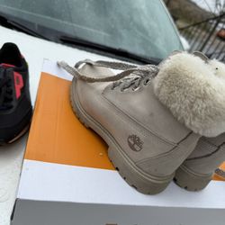 Adorable light beige Timberland boots.  Faux fur trim. Lace-up style.  Great for winter.  Comes in original box.