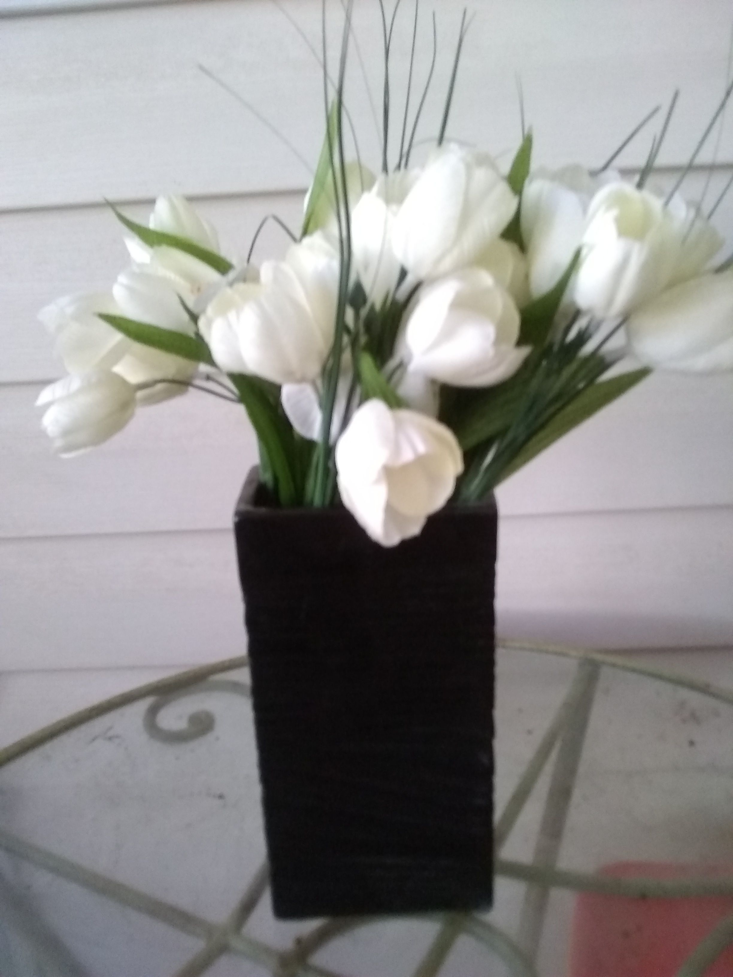 Artificial white flowers in black vase