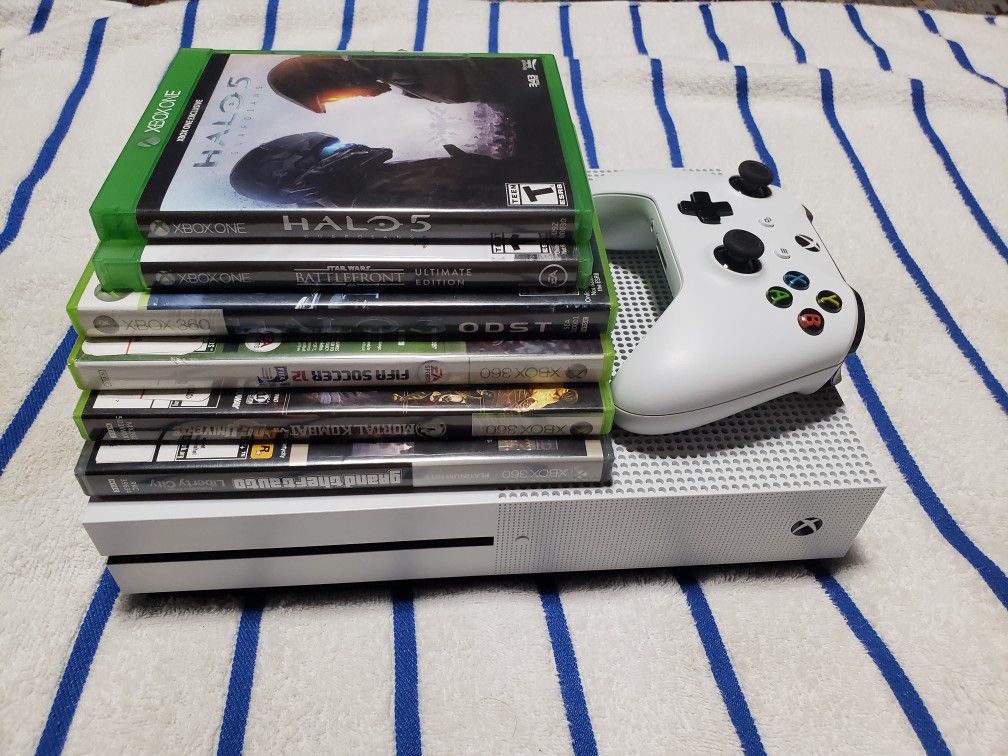 white Xbox One console with controller and game