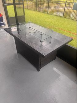 Ratan fire table with blue glass and wind guard