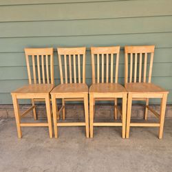 Four wood bar-height chairs