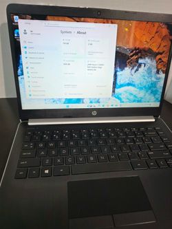 Black and silver HP laptop running Windows 11 with an AMD Ryzen processor and Radeon graphics. Full-size keyboard, integrated webcam, and clean condit