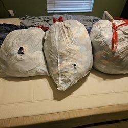 Three very full bags of boys clothes