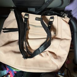 This is a Steve Madden light pink handbag with black straps.