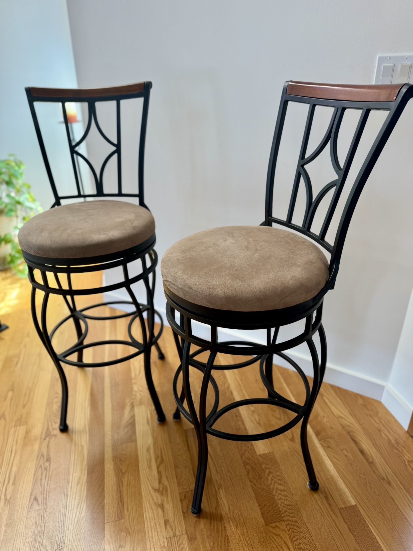 Classic black iron swivel bar stools with wood accent and beige microfiber cushions