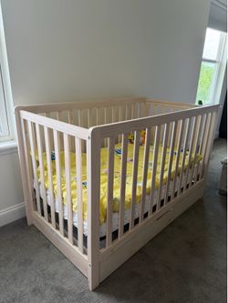 Baby nursery furniture set in excellent condition. Includes a solid wood crib with a large storage drawer underneath and a matching 6-drawer dresser w