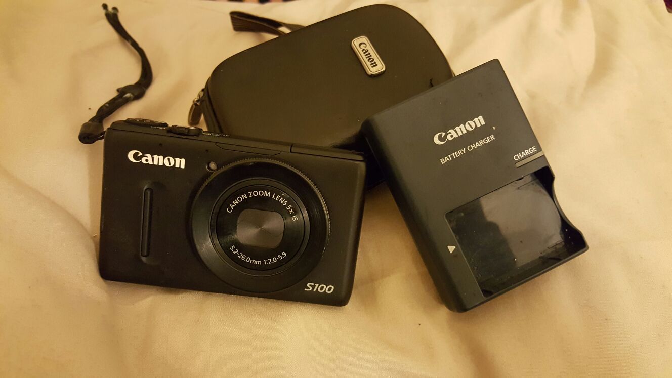 High end Canon camera (<s100> zoom lens 5x is)with a canon battery charger and canon camera case