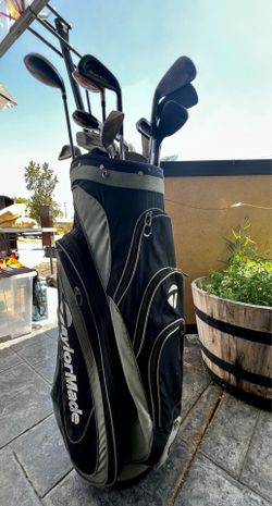 Taylor made golf bag with assorted golf clubs