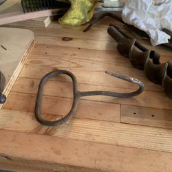 It is a heavy-duty, hand-held tool used for lifting and moving hay bales, meat, or ice. 