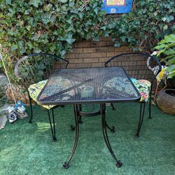 Wrought iron bistro set with cushions