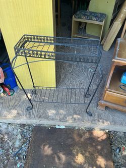 Black Metal 2-Tier Plant Stand it’s 27 inches tall 24 inches wide 9 inches deep