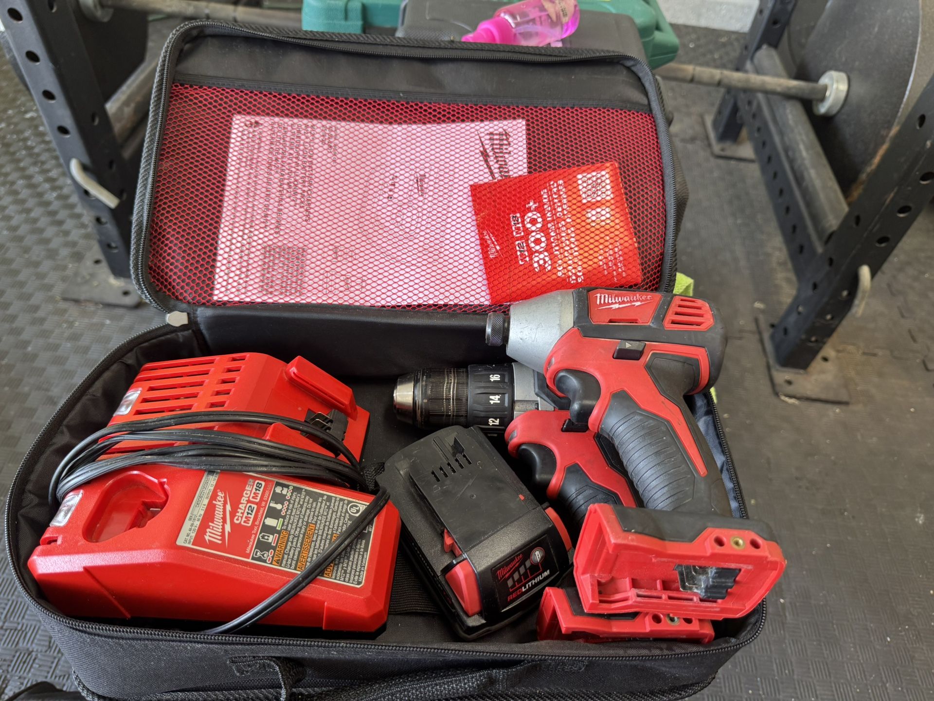 milwalukee M18 combo kit with one M18 drill, one M12 drill, M12 & M18 dual charger, one red lithium battery, & soft outer case