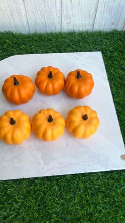 artificial orange decorative foam or plastic mini pumpkins featuring dark brown ribbed stems, commonly used for autumn and Thanksgiving tabletop