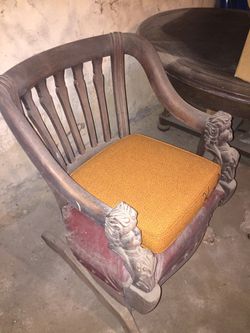 Antique wood chair with carved armrest