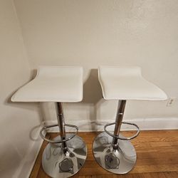 Pair Of White Faux Leather Adjustable Height Bar Stools With Chrome Base And Foot Rest