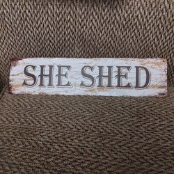 SHE SHED METAL SIGN.  16" X 4".  NEW. PICKUP ONLY.