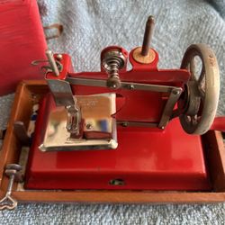 Red Vintage Toy, child's hand crank chain stitch sewing machine with carrying case