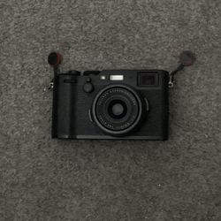 black fujifilm x100f with light, tripod, and strap