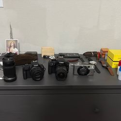 Three Cameras, a canon r100, a canon rebal xs, and a canon film camera 