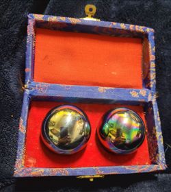 Chinese Baoding balls, also known as exercise or meditation balls, nestled in a traditional silk-brocade storage box. Originating from Baoding, China,