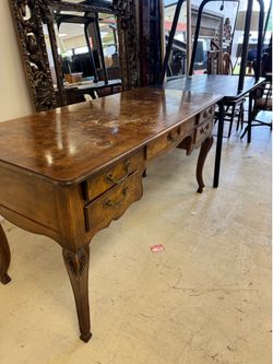 Vintage Desk features a distinctive burl walnut finish and ornate cabriole legs - 60” x 24”