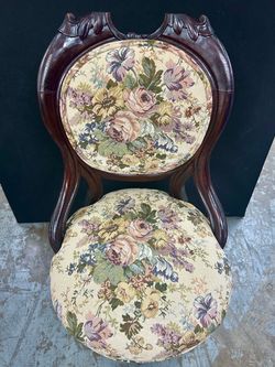 Victorian-style petite parlor chair dark carved wooden frame and floral upholstery