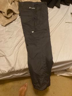 black Columbia outdoor utility or snow pants feature a zippered thigh pocket and signature branding near the waistband.