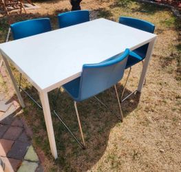 IKEA MELLTORP dining table and four IKEA BERNHARD dining chairs in blue leather