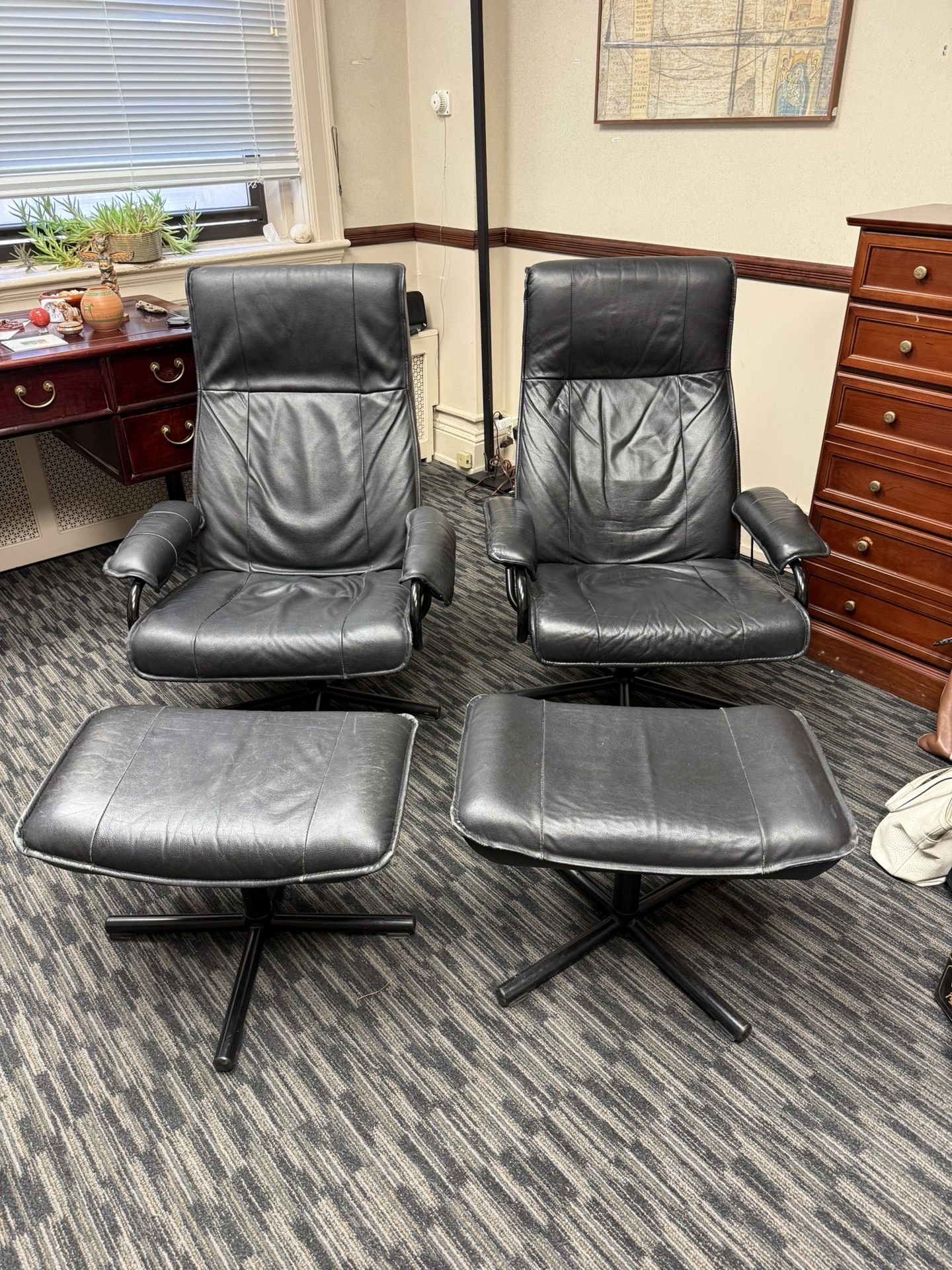 Two Black Leather Reclining Chairs With Matching Footstools