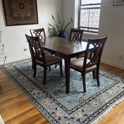 Dining Table And 4 Chairs And A Floral Area Rug