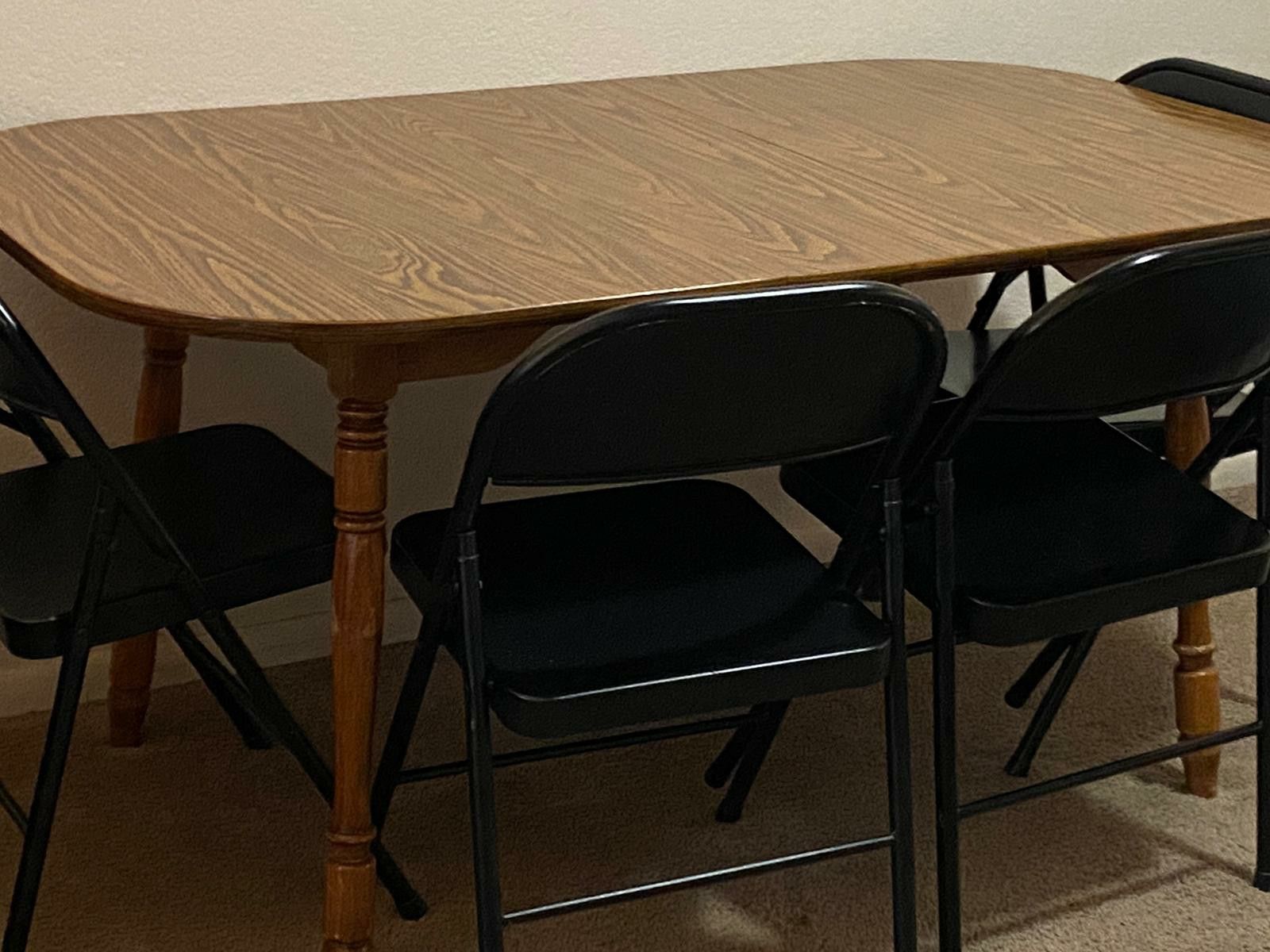 A wooden table and 4 floding metal chairs