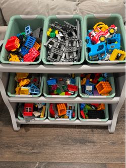 Set of large duplo legos and organizer shelf with bins