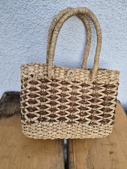 A handwoven straw or raffia basket bag