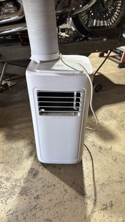 Small room portable air conditioner unit includes remote and accessories.