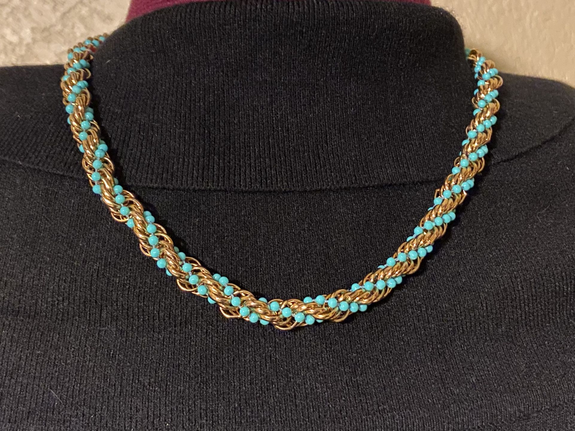 The Vintage Avon Twist Rope Necklace from 1972 features a stylish gold tone design with turquoise beads, measuring 20 inches in length. This original