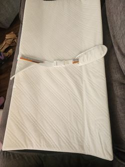 White quilted baby changing pad with safety strap
