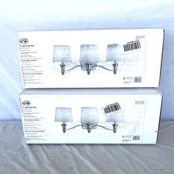 (2) Brand New In The Boxes (Hampton Bay) Three Light Basketball Light Fixtures. Brush Nickel Finish With White Cloth Shades, Retails For $99 Each. I’l