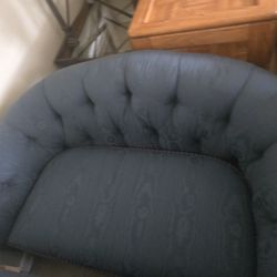 Comfortable blue sofa with two patterned cushions.