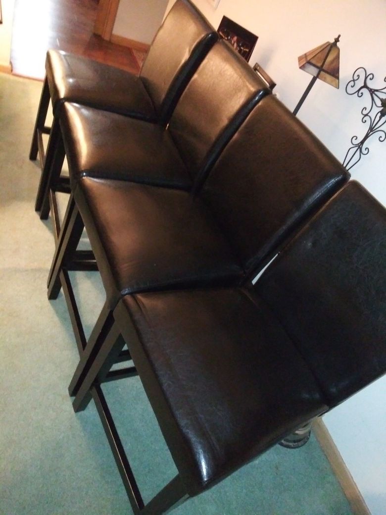 4 faux black leather chairs. Excellent condition ! No rips! No tears! No fading !!! Like new ! Bar height.