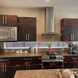 Flat panel kitchen cabinets with microwave, range hood, sink and granite