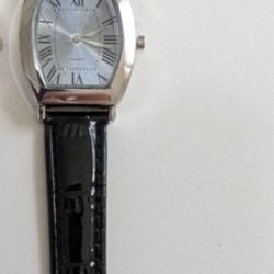 New  stylish watch with black leather strap and silver dials. 
It still has the protective cover on the face and the stem.