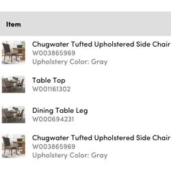 Wayfair Marble top dining table with gray upholstered chairs.