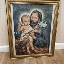 Ornate framed tapestry piece depicts Saint Joseph holding the Child Jesus 