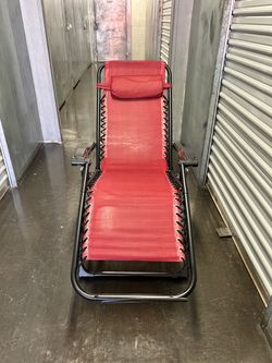 lounge chair featuring a sturdy black metal frame and an adjustable matching headrest pillow